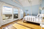 Master bedroom with Queen bed, private deck and view of the bay on the second floor